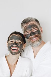 https://www.anushkaspa.com/wp-content/uploads/2020/06/Source-Pinterest-2.jpg a man & women wear white bath robe have black facial mask on their face