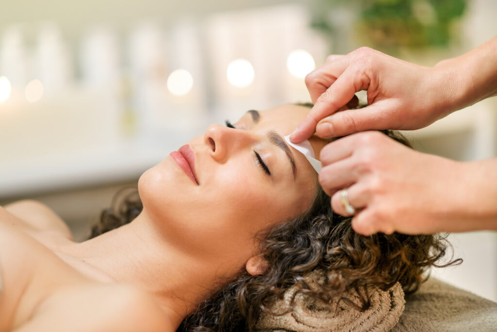 woman relaxing while having her eyebrows waxed