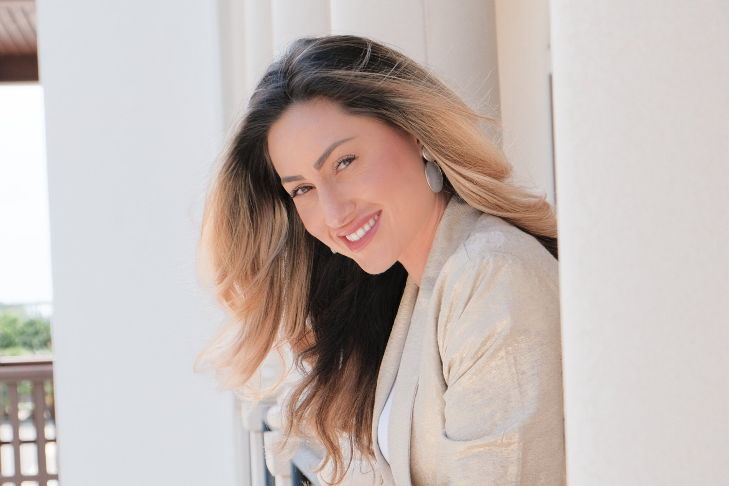 A female client smiles at the camera, happy with her hair after going to our organic hair salon in West Palm Beach.