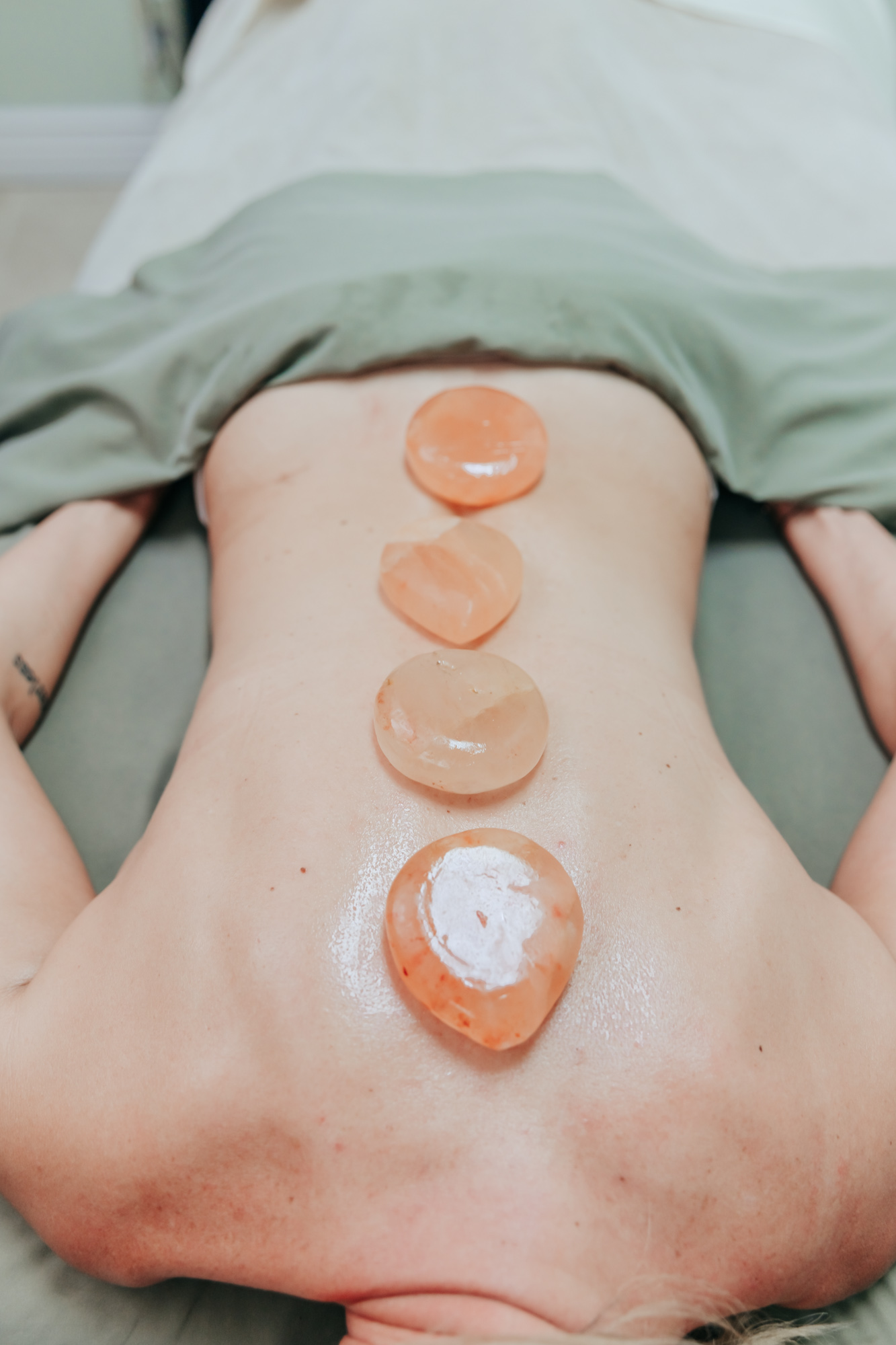 Client with hot stones on back while relaxing durning massage