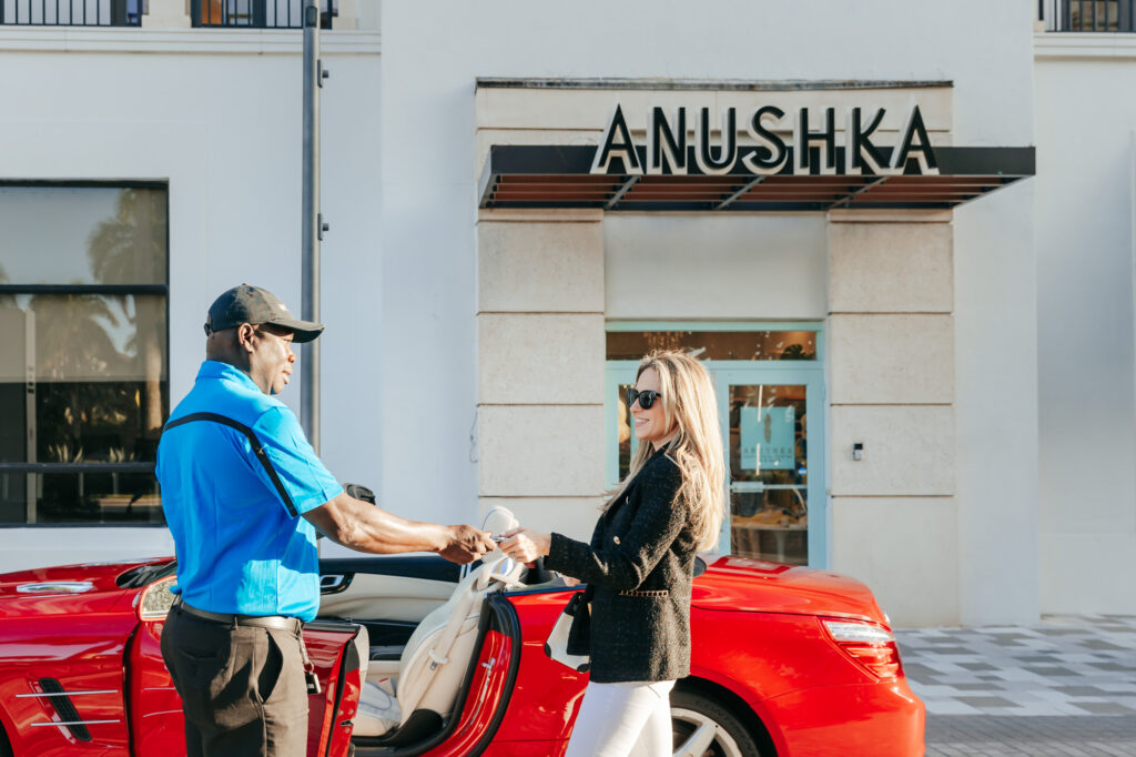 Valet handing smiling woman her keys as she leaves Anushka Spa Salon.